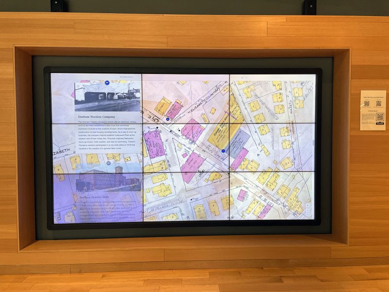 display-wall A large screen set in a recessed niche in a wooden wall, displaying