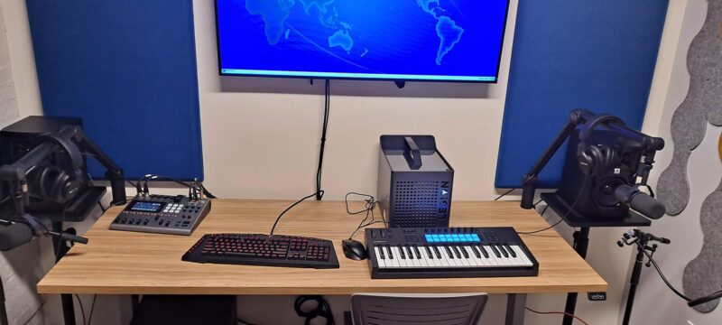 Recording equipment including a computer, keyboard, microphone, headphones, and mixing board.
