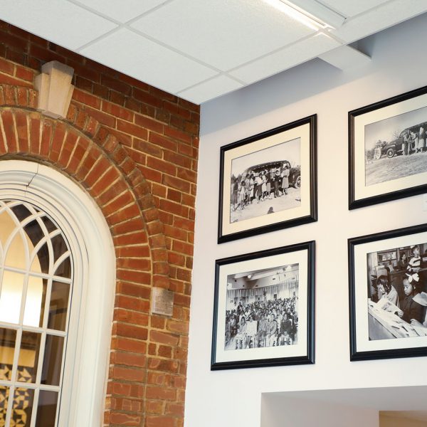 Framed black-and-white photographs with scenes from Stanford L. Warren's history hanging on the lobby walls