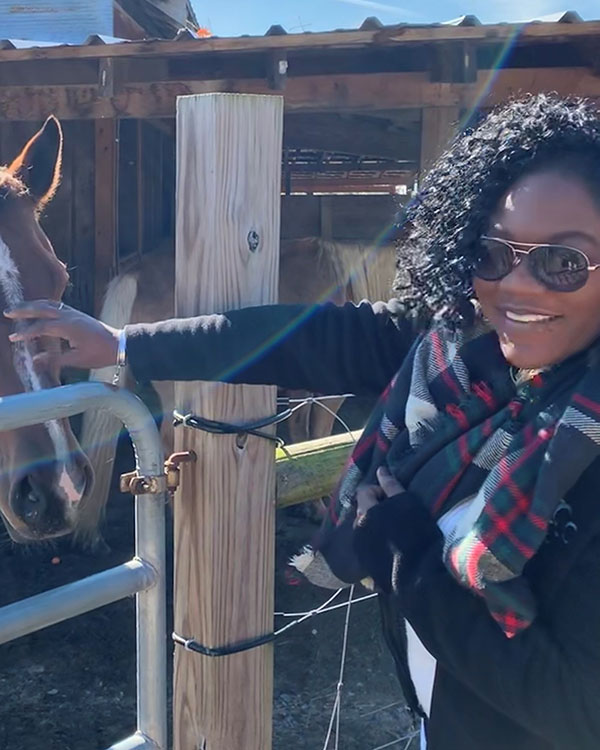 East Regional children's manager Diamond petting one of the equine stars of East Regional's Storytime with Horses