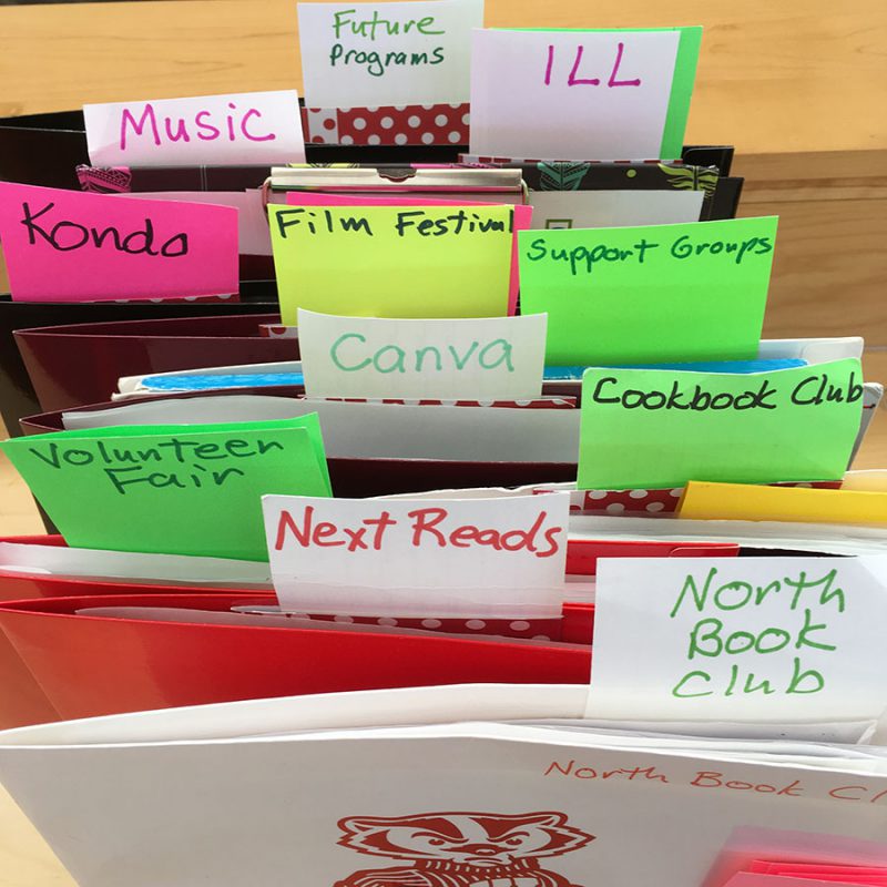 Tagged file folders representing Emily's many library interests and activities, including book clubs, the volunteer fair, and more