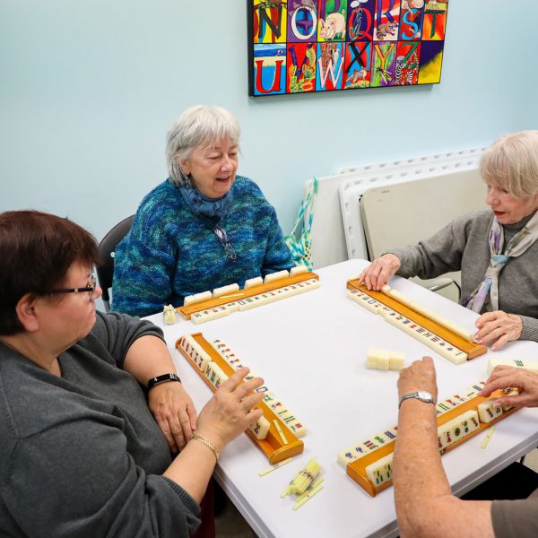 A group of women sitting around a table playing mahjong