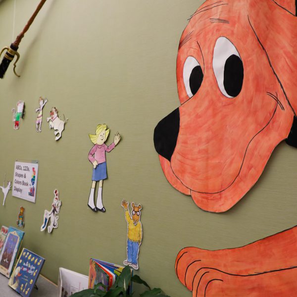 A wall with cutouts of Clifford, Arthur, and other children's book characters