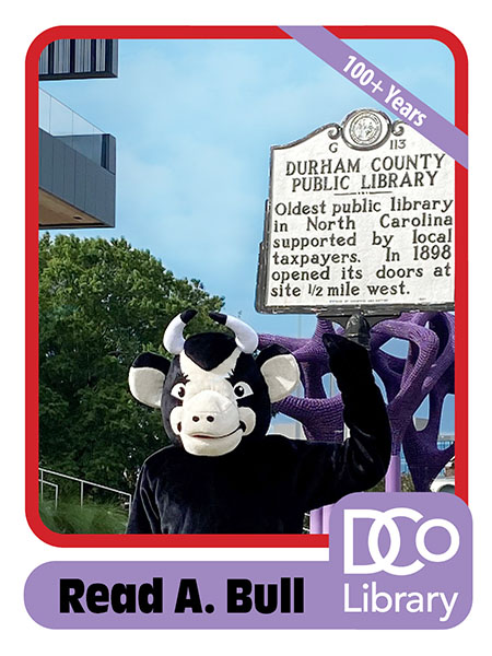 Costumed mascot Read A. Bull standing in front of Main Library, next to a historical marker reading: "Durham County Public Library - Oldest public library in North Carolina supported by local taxpayers. In 1898 opened its doors at site 1/2 mile west."