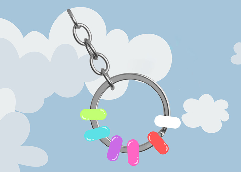 A silver key ring with colorful beads along the ring part, floating against a calm blue sky with pale fluffy clouds.