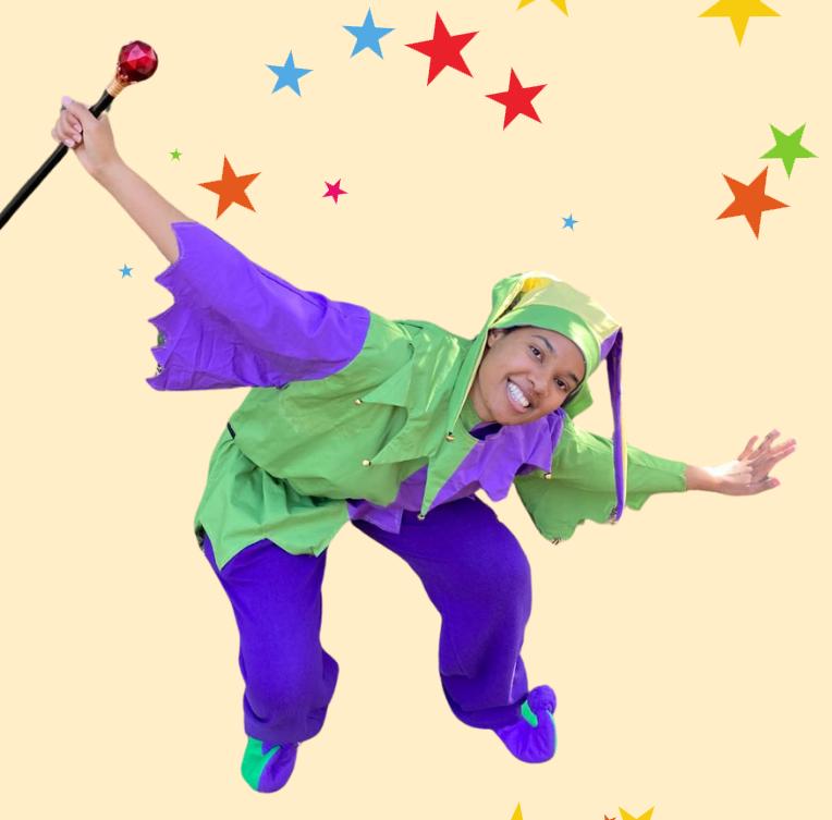 A person in a green-and-purple jester's costume, smiling and making a deep bow.