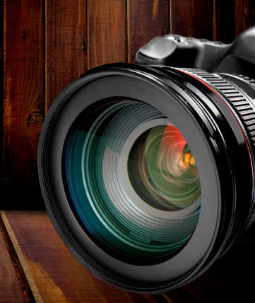 A closeup of a camera lens in a wood paneled room - dark and mysterious.