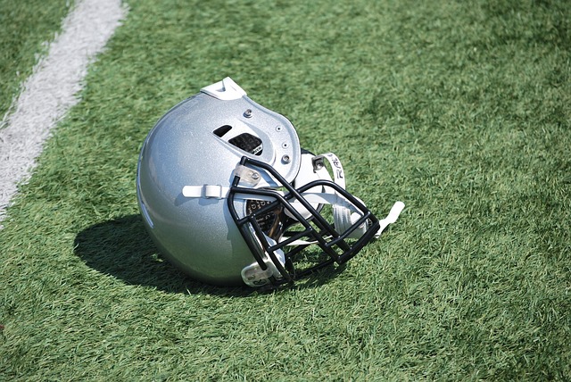 A silver football helmet lying on a turf field.
