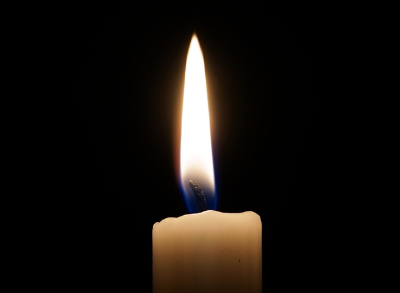 A lit candle on a black background.