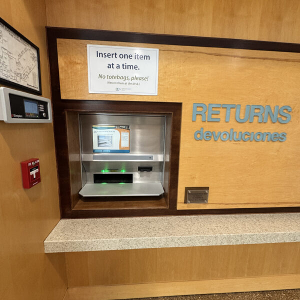 An automated book return in a wooden wall.